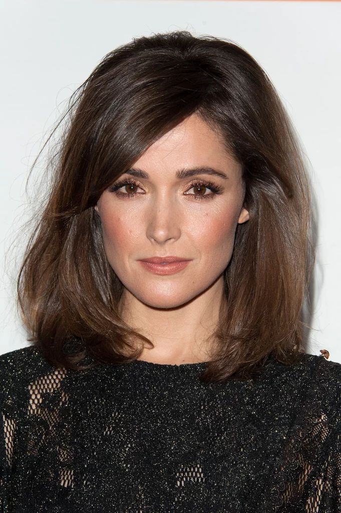 a close up of a person wearing a black dress and posing for the camera with her hand on her hip