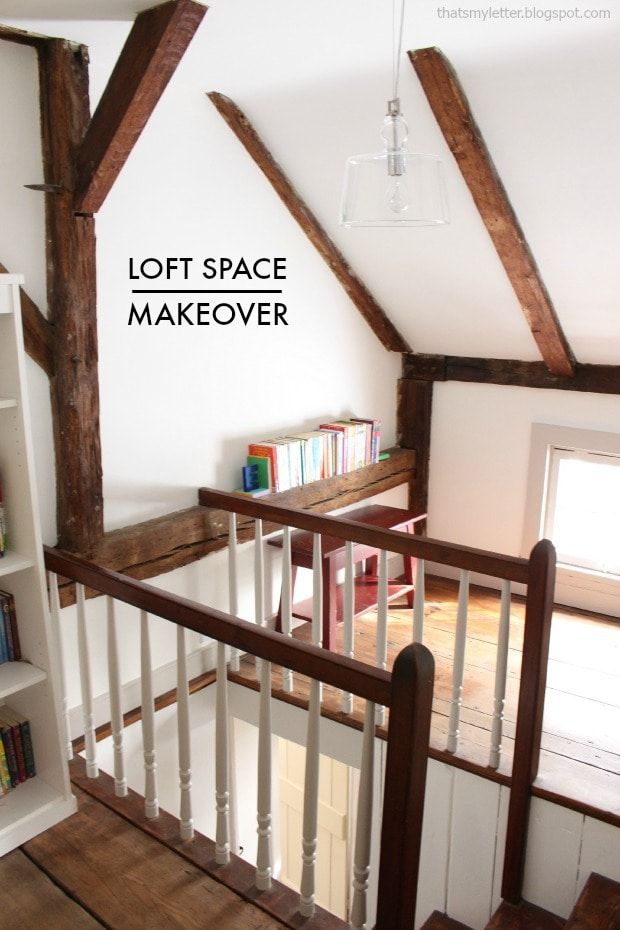 loft space makeover with white painted walls and wood beams on the ceiling, along with bookshelves