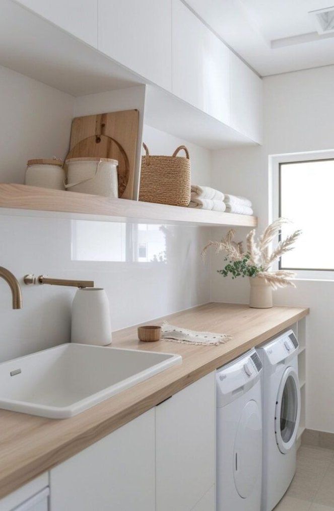 a washer and dryer in a white laundry room with open shelving on the wall