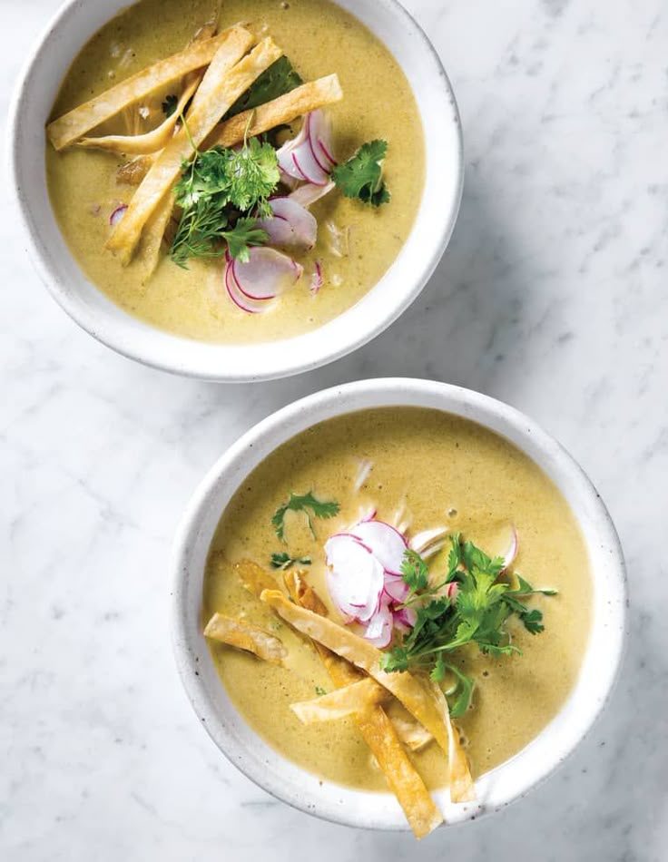 two bowls filled with soup on top of a table