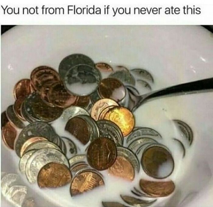 a white bowl filled with lots of coins and a spoon sticking out of the top