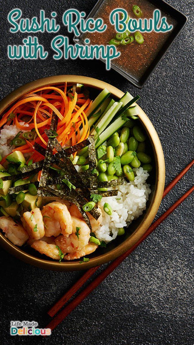 sushi rice bowls with shrimp, carrots and green beans in a bowl next to chopsticks