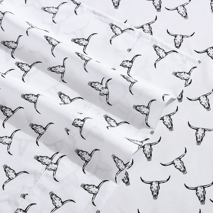 an image of white fabric with black and white birds on the print, as well as other patterns