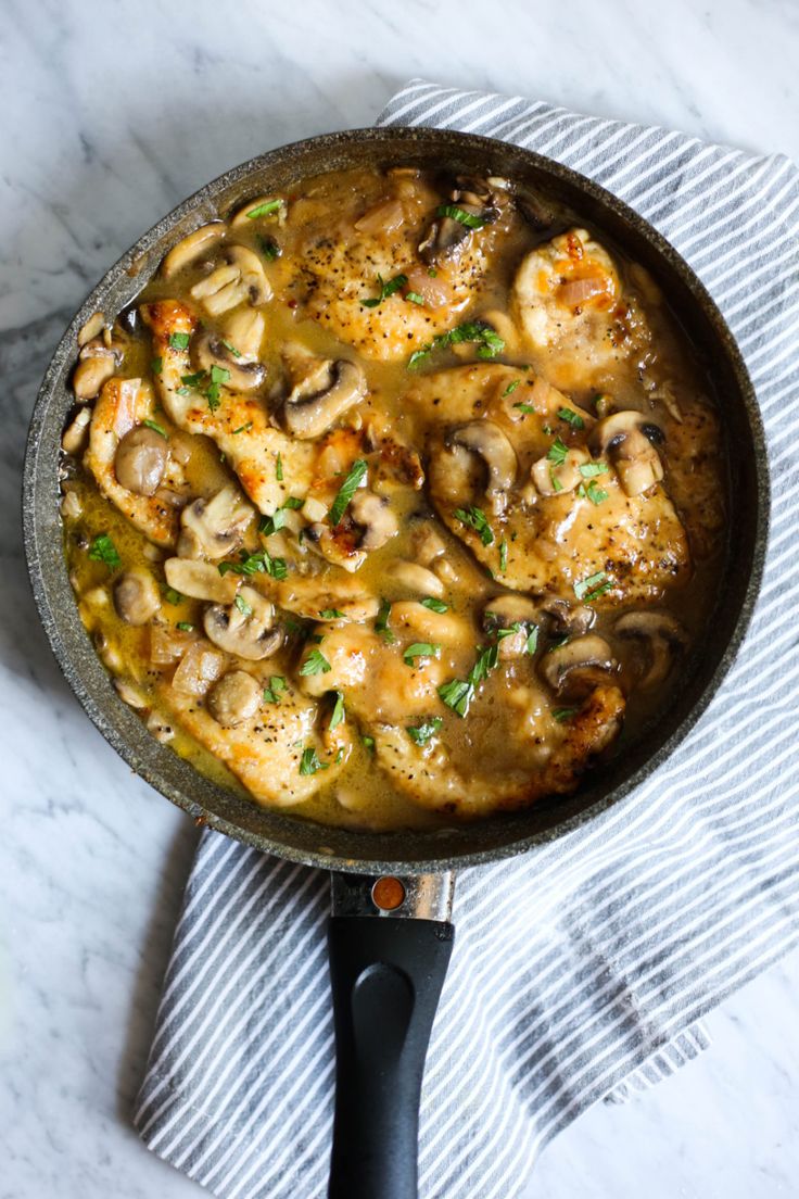 a skillet filled with chicken and mushrooms