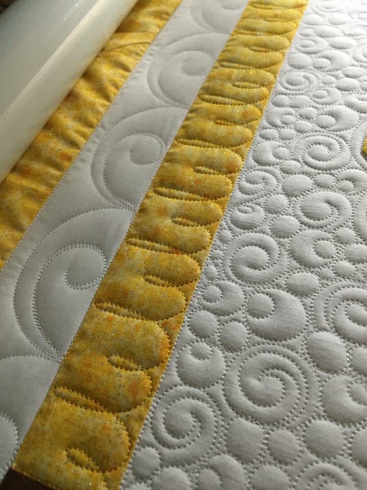 a close up view of a quilted table runner with yellow and white circles on it