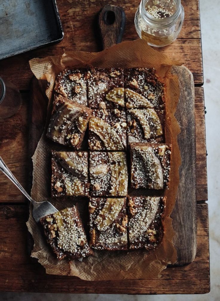 a wooden cutting board topped with brownies and powdered sugar on top of it