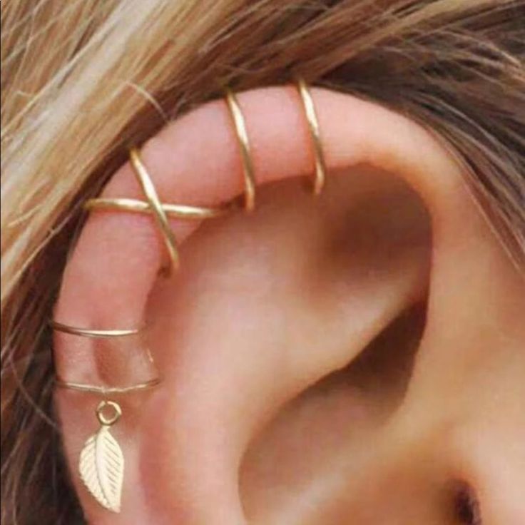 a woman's ear with two thin gold rings