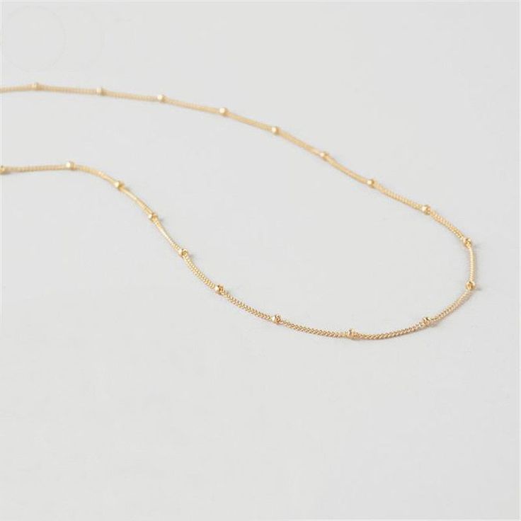 This simple, tiny, short beaded chain necklace is the perfect base to start layering your necklaces. It's very short, but not quite choker length, so it won't get lost within your other pieces. However, this is also a great necklace to wear alone with a higher collar dress or tee! It lays beautifully on top of your collar bone. *Please keep in mind that this necklace will be a little shorter or longer on your depending on the circumference of your neck. DETAILS & SIZE Composition: 18K gold p Delicate Choker Necklace With Satellite Chain, Delicate Satellite Chain Choker Necklace, Minimalist Beaded Chain Layered Necklace, Minimalist Everyday Beaded Chain Layered Necklace, Minimalist Tiny Beads Chain Necklace For Everyday, Minimalist Beaded Necklace With Delicate Adjustable Chain, Everyday Tiny Beads Choker, Minimalist Adjustable Beaded Necklace With Delicate Chain, Minimalist Layered Choker Necklace