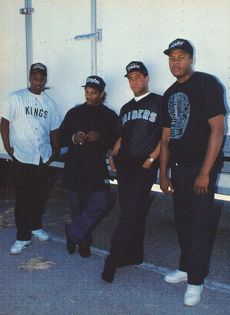 three men standing next to each other in front of a truck