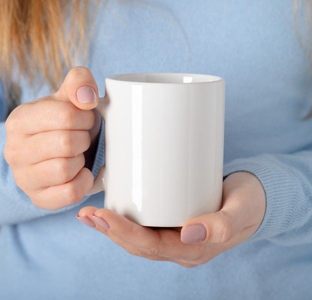 a woman holding a white coffee cup in her hands