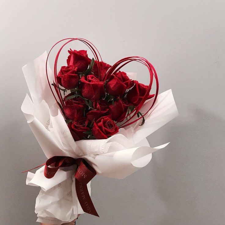 a person holding a bouquet of red roses