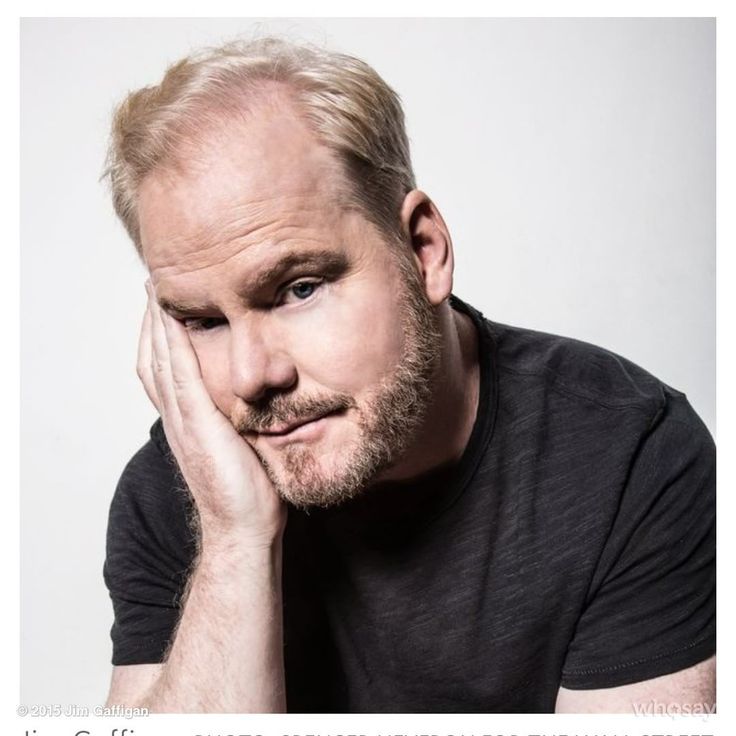 a man with blonde hair and beard is looking at the camera while holding his hand to his face