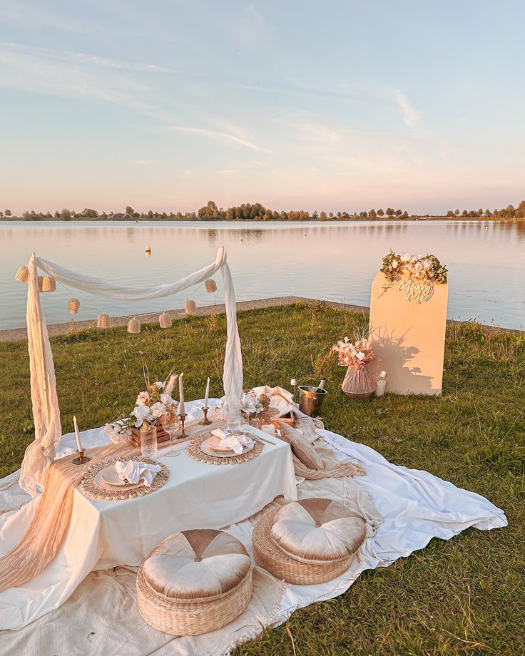 a table set up on the grass near water