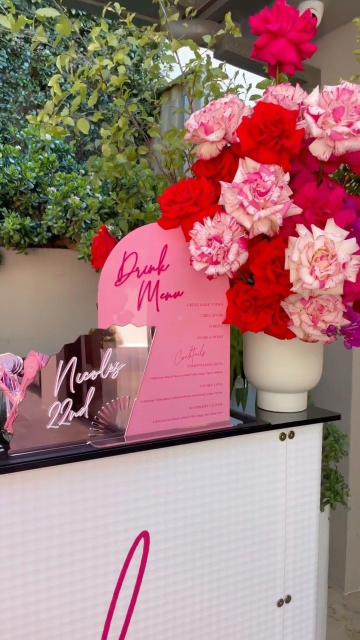 pink and red flowers on display in front of a sign that says bride to be