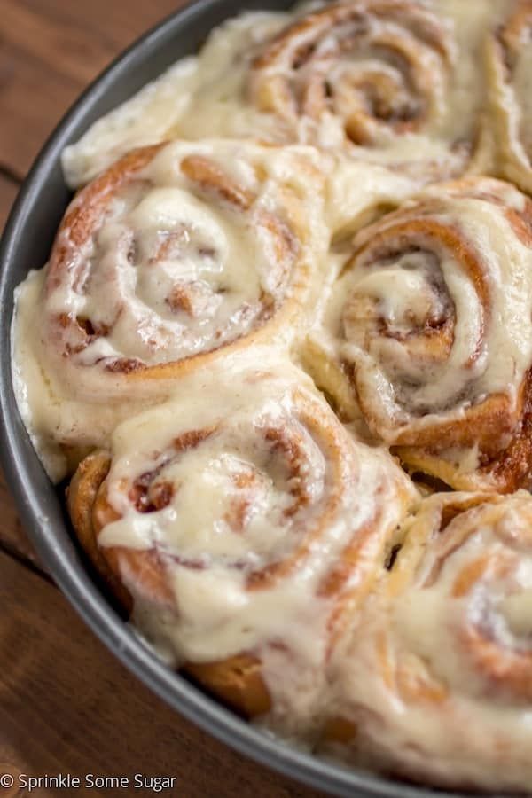 a pan filled with cinnamon rolls on top of a wooden table