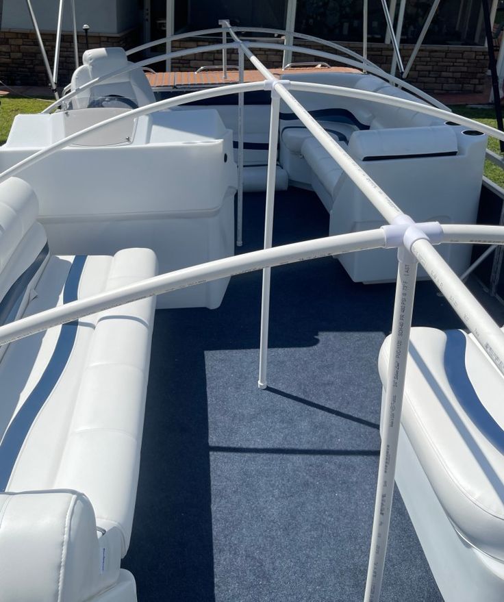 the inside of a boat with white leather seats and railings on the back deck