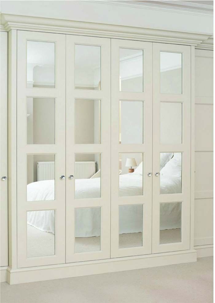 an image of a bedroom with mirrored doors on the wall and bed in the background