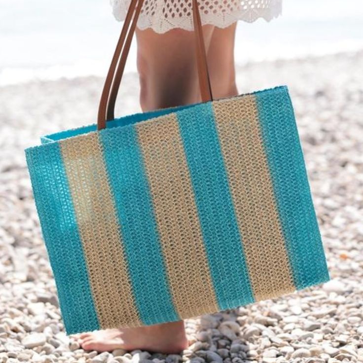 Brighten up your beach look with Shiraleah's Filomena Stripe Straw Tote. Made from lightweight paper straw, it features sleek circular handles and a colorful stripe pattern. Perfect for carrying all your essentials, make a fashion statement in the sun with this playful and roomy tote. Made in China Paper straw and PU Double shoulder straps Magnetic snap closure 1 inner slip pocket Dimensions: 17.5 x 7 x 12 in (44.5 x 17.8 x 30.5 cm) Color: Turquoise & Natural Stripe Striped Beach Bag For Everyday Summer Use, Summer Beach Bag With Striped Lining, Summer Beach Tote With Striped Lining, Striped Summer Style Bag, Summer Striped Woven Straw Bag, Striped Beach Bag For Travel, Casual Striped Straw Bag For Beach, Casual Striped Woven Straw Bag, Casual Striped Straw Bag For Vacation