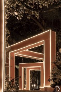 the entrance to an art gallery lit up at night with lights and trees in the background