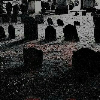 an old cemetery with tombstones in the foreground and red light at the top