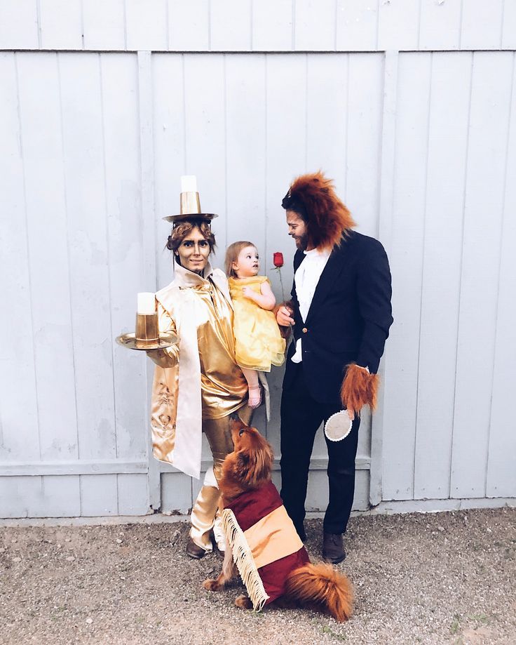 two people in costumes standing next to a dog and a man with a baby on his lap