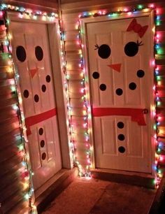 two white doors decorated with christmas lights and snowman faces on the side of them