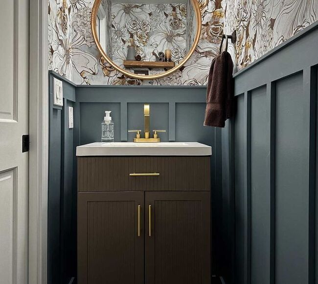 a bathroom with blue walls and gold accents on the mirror above it is an image of a sink