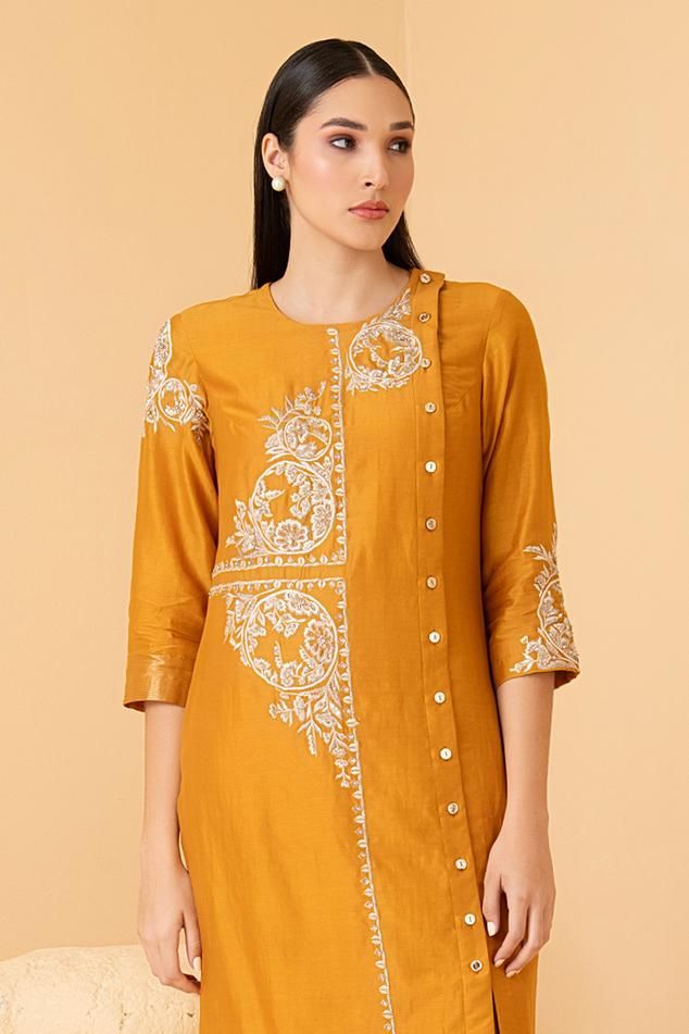 Mustard tunic with zari, sequin, pearl embroidery in floral pattern. Paired with pant.
Components: 2
Pattern: Embroidery
Type Of Work: Zari, sequin, pearl, floral
Neckline: Round
Sleeve Type: Three quarter
Fabric: Pure Chanderi
Color: Yellow
Other Details: 
Front button detailing
Attached lining
Length:
Sleeves: 18 inches
Weight: 1.5 kgs
Occasion: Mehendi and Haldi - Aza Fashions Pearl Embroidery, Pattern Embroidery, Types Of Work, Embroidered Tunic, Pant Set, Set For Women, Aza Fashion, Fashion Set, Sleeve Type