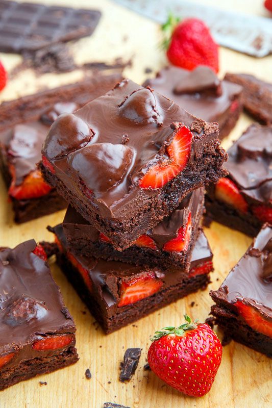 chocolate brownies with strawberries on a cutting board