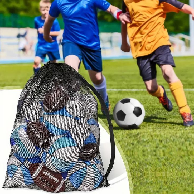 two young boys playing soccer on a field with a mesh bag in the foreground