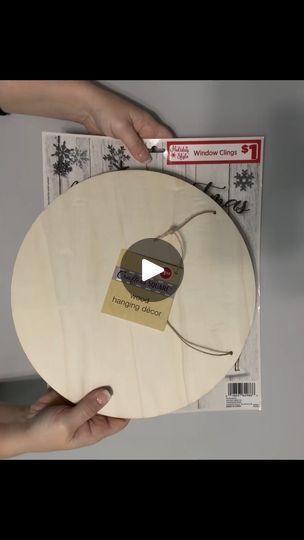 someone holding up a wooden disc with the label on it