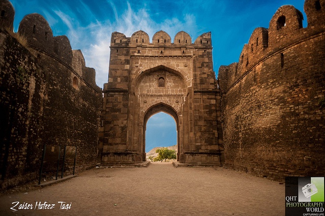 the entrance to an old castle with a blue sky in the background