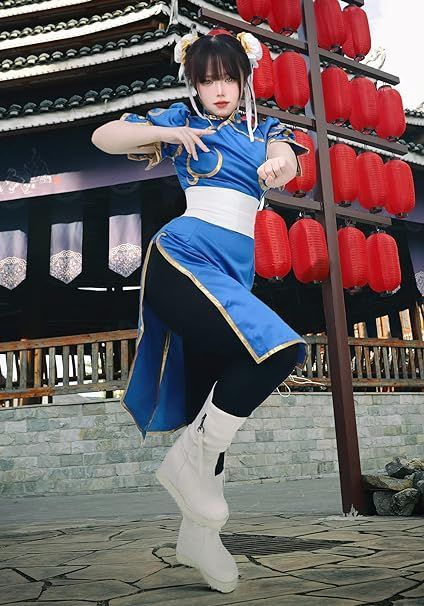 a woman dressed in blue and white is posing for the camera with red lanterns behind her