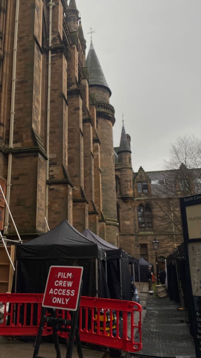 a red barricade in front of an old building with a sign that says film access only