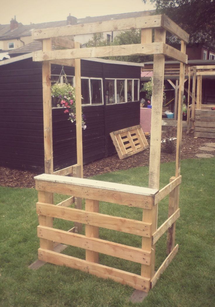 a wooden structure sitting on top of a lush green field