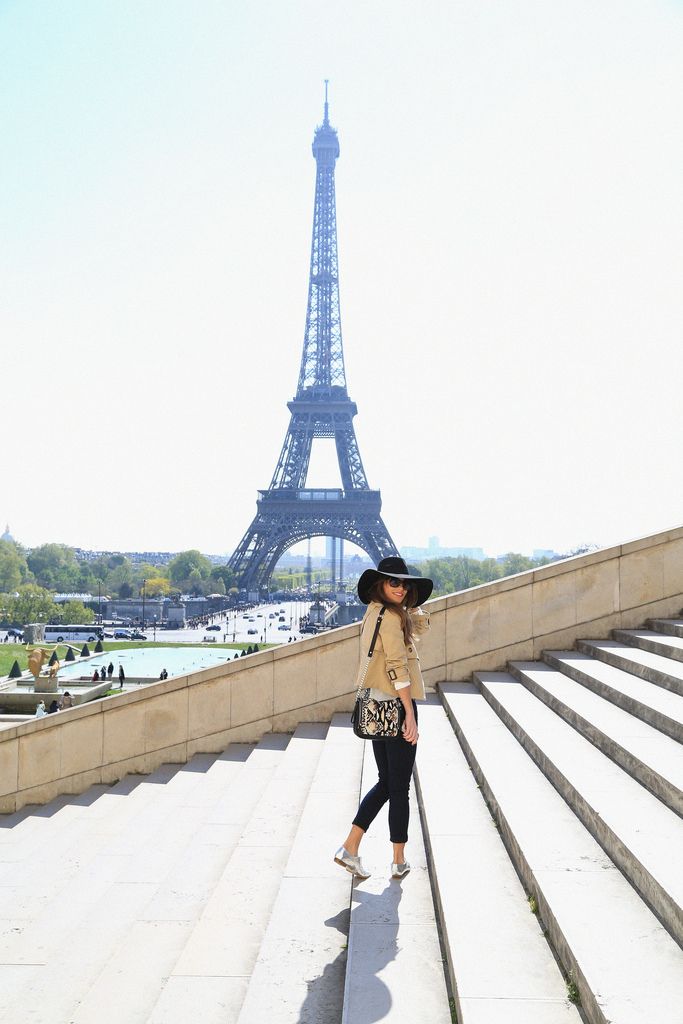 a woman standing in front of the eiffel tower with her hand on her hip