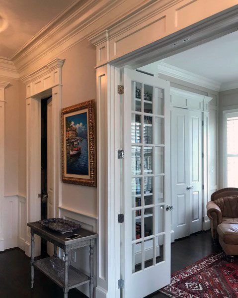 a living room filled with furniture and a painting on the wall next to a doorway