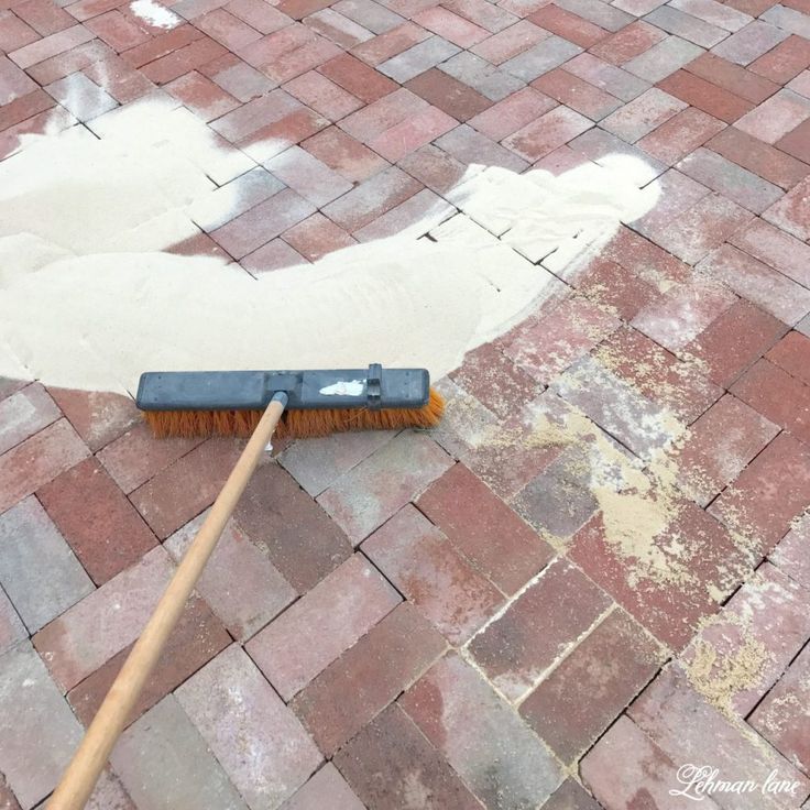 a broom is laying on the ground next to a brick floor that has been cleaned