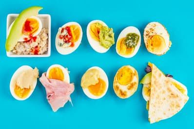 an assortment of different types of food on a blue background, including eggs and meats