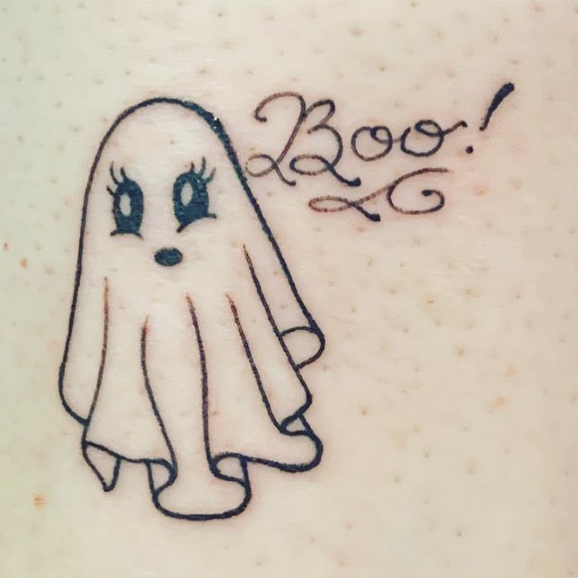 a ghost tattoo with the word boo spelled in cursive writing on it's side