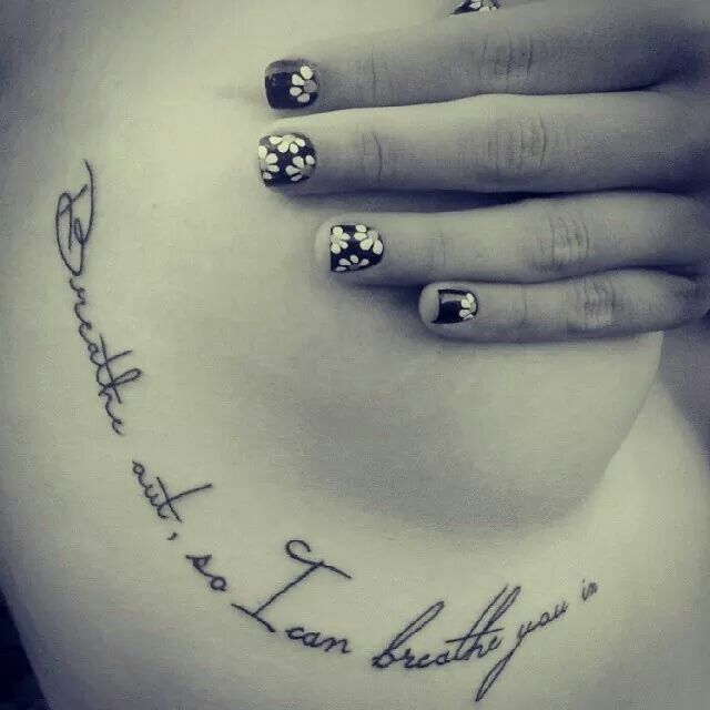 a woman's belly with tattoos and writing on it