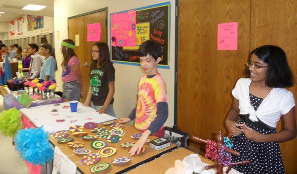 a group of young people standing around a table