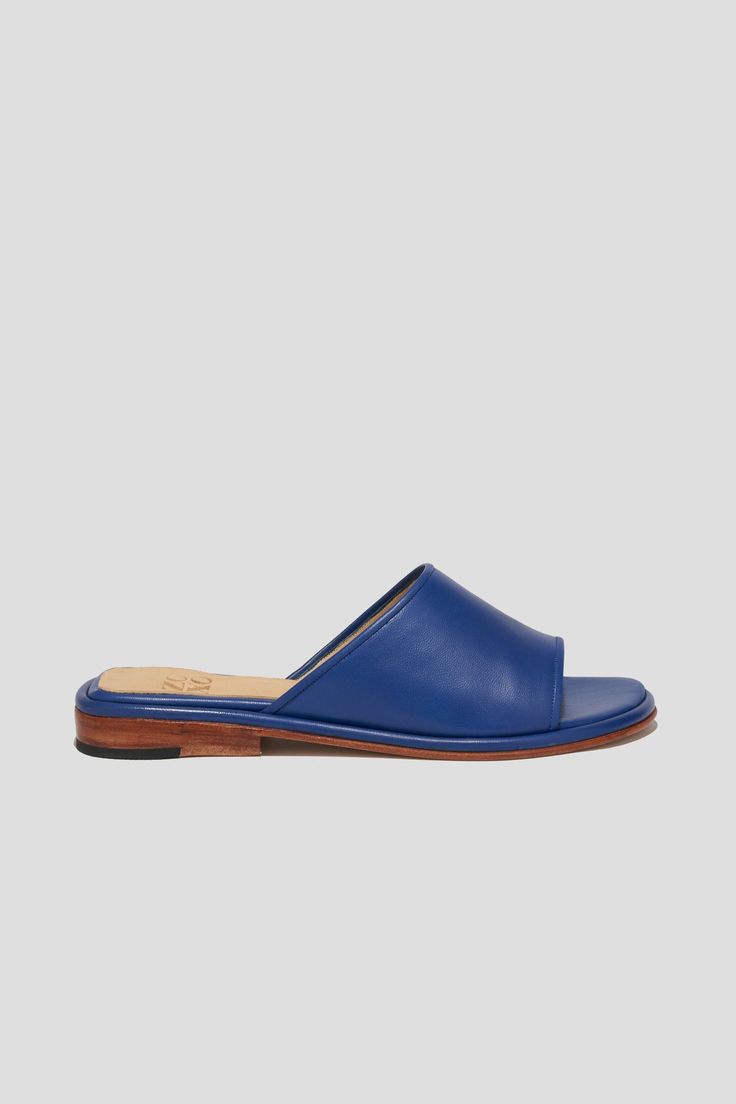 Get ready for the Pileta Slide in Cobalt to be your favorite summer shoe. It's got the ease of a flip-flop but is as finely crafted as any shoe in our collection, which means it's going to be a keeper. Its simple shape and stand-out color will make it easy to combine with a range of textures, fabrications and silhouettes in your summer wardrobe. Who it's for: The woman who loves a pop of color. Kidskin upper with vegetable tanned leather lining and a 25 mm stacked leather heel and sole. Handmade in Argentina. Blue Open Toe Slides With Rubber Sole, Summer Closed Toe Slippers With Stitched Sole, Blue Open Toe Slippers With Removable Insole, Modern Blue Summer Mules, Summer Slides With Stitched Sole And Open Toe, Summer Open Toe Slides With Stitched Sole, Blue Summer Slippers With Rubber Sole, Summer Blue Slippers With Rubber Sole, Modern Blue Mules For Summer