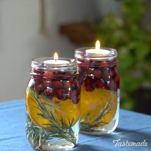 two mason jars filled with lemons and cranberries on top of a table