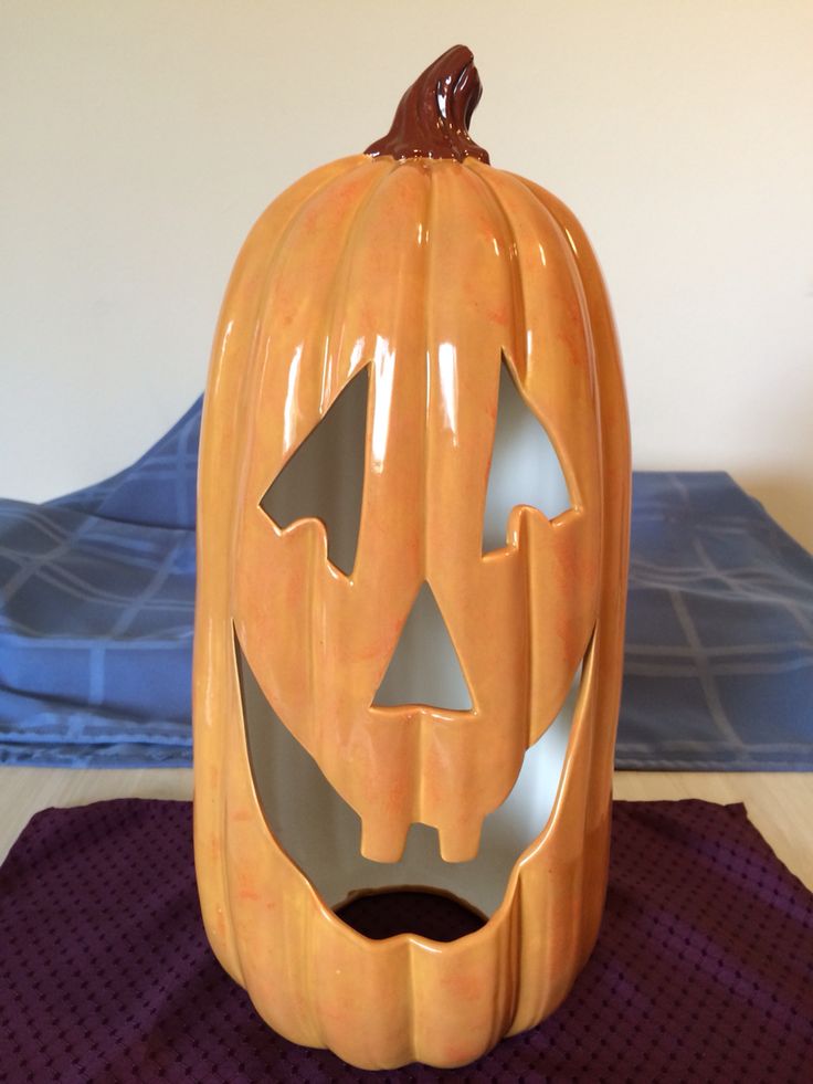 a pumpkin shaped container sitting on top of a purple mat