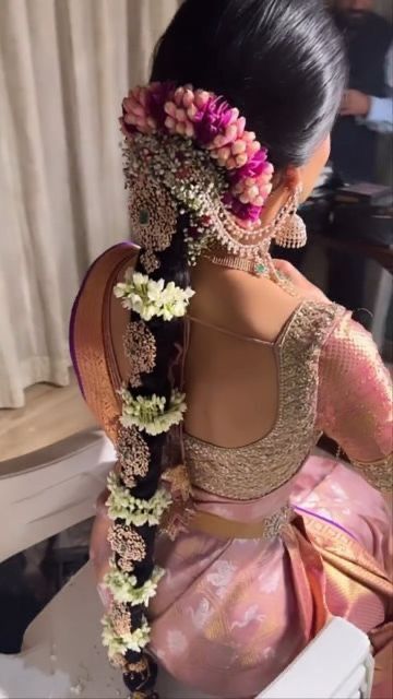 a woman sitting on top of a chair with flowers in her hair