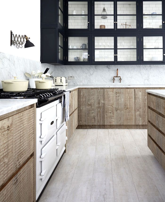 a kitchen with wooden cabinets and marble counter tops, along with an oven in the center