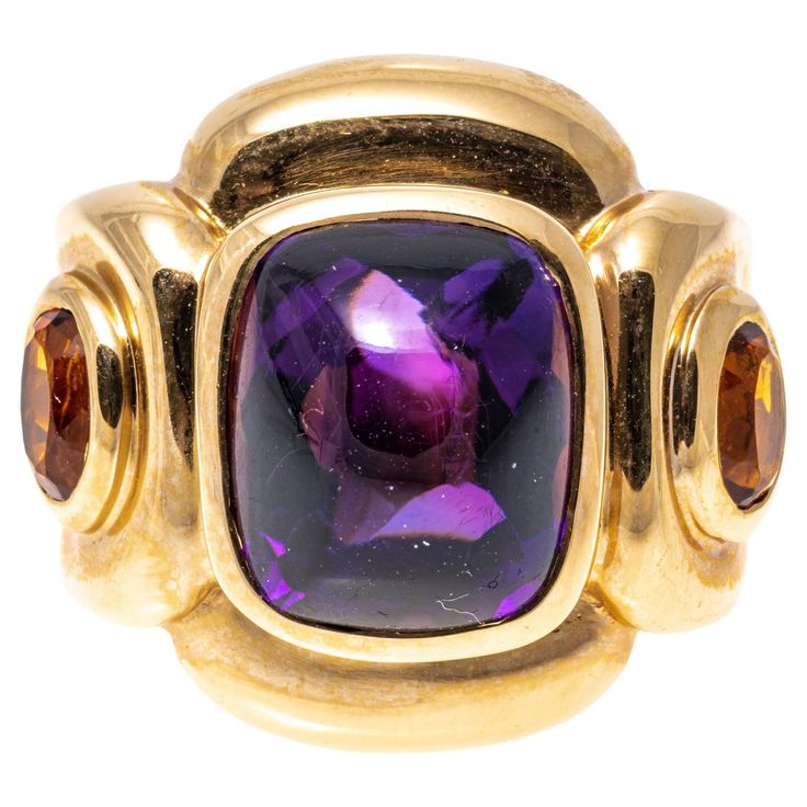 14k yellow gold ring. This impactful ring has a rectangular sugarloaf cabochon cut dark purple color amethyst center, bezel set and flanked by two oval faceted, dark orange color citrines, approximately 0.18 TCW, also bezel into a chunky, contemporary rectangular profile mounting. Marks: 14k Dimensions: 13/16" across the top x 11/16" wide Weight: 9.3 gross dwt Ring Size: 6.5 Dark Orange Color, Amethyst Cocktail Ring, Dark Purple Color, Yellow Gold Cocktail Ring, Amethyst And Citrine, Serpent Ring, Amethyst And Diamond Ring, Gold Cocktail Ring, Gold Cocktail