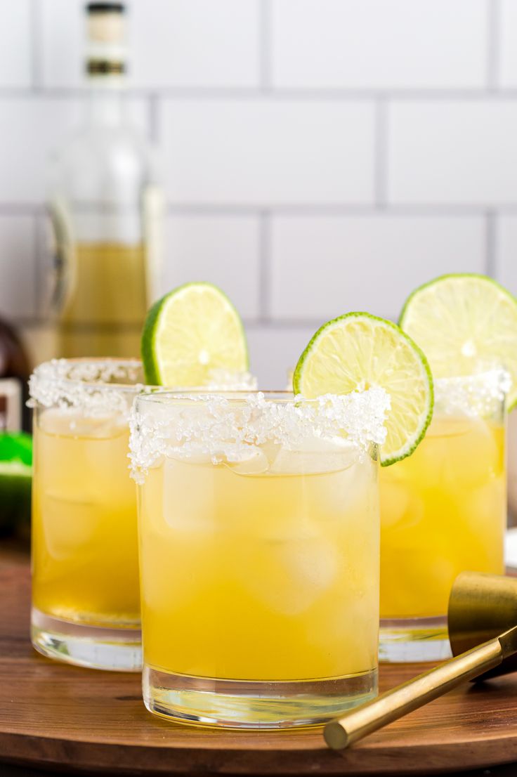 two glasses filled with lemonade and lime slices