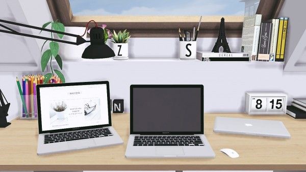 two laptops sitting on top of a wooden desk next to a clock and other office supplies